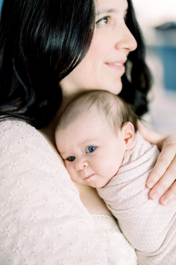 Mom holding her baby on her shoulder in a Tampa newborn photography in home session.
