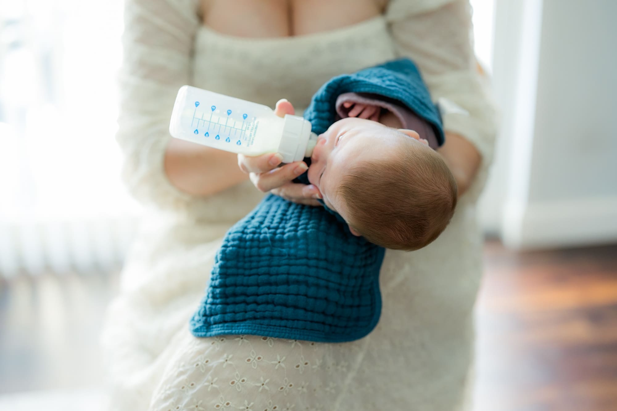 Baby feeding from a Dr. Brown's bottle in elevated side-lying position.
