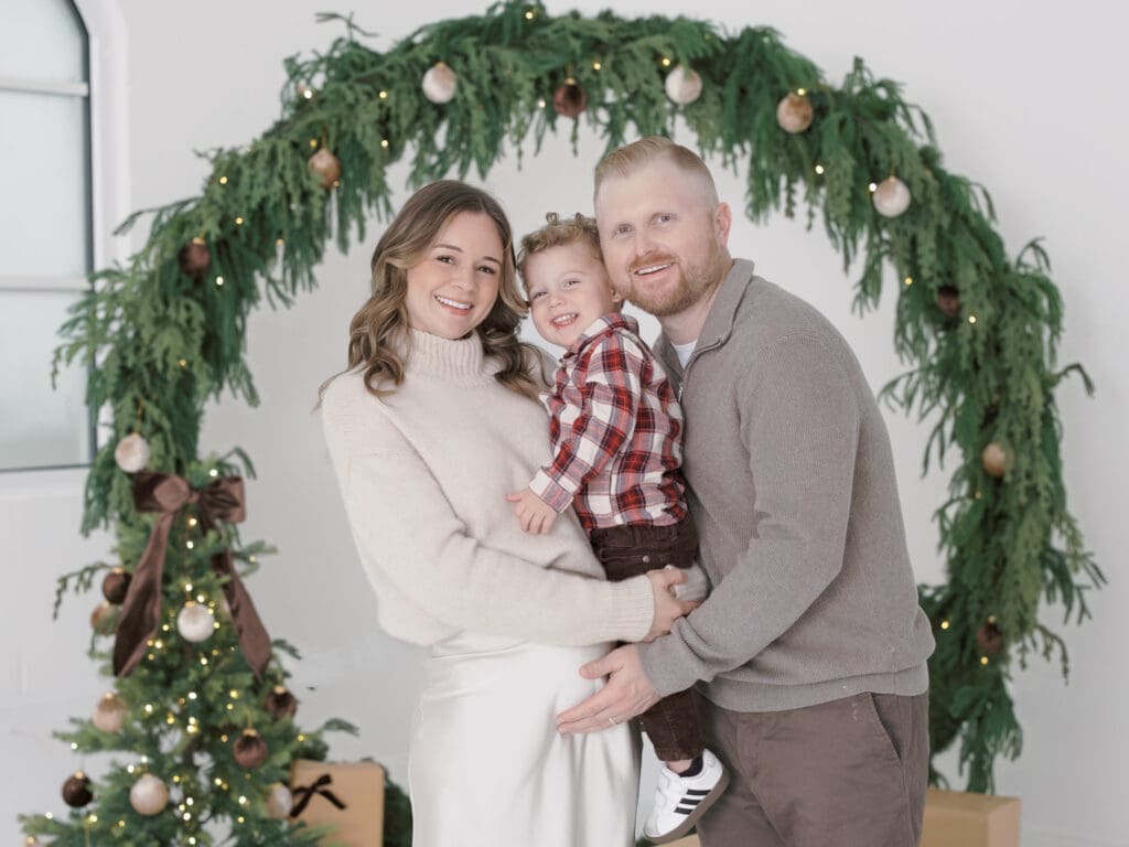 Parents and a little boy wearing coordinated outfits for their Christmas Family Photos.