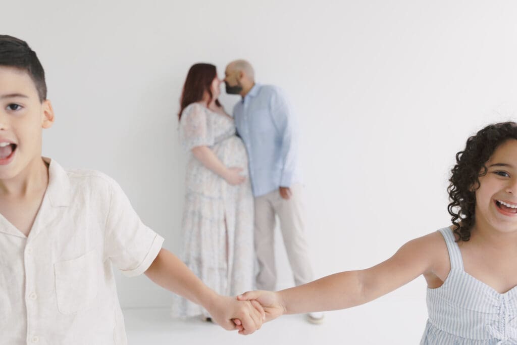 Profressional photo of a family maternity session with two kids framing their parents.