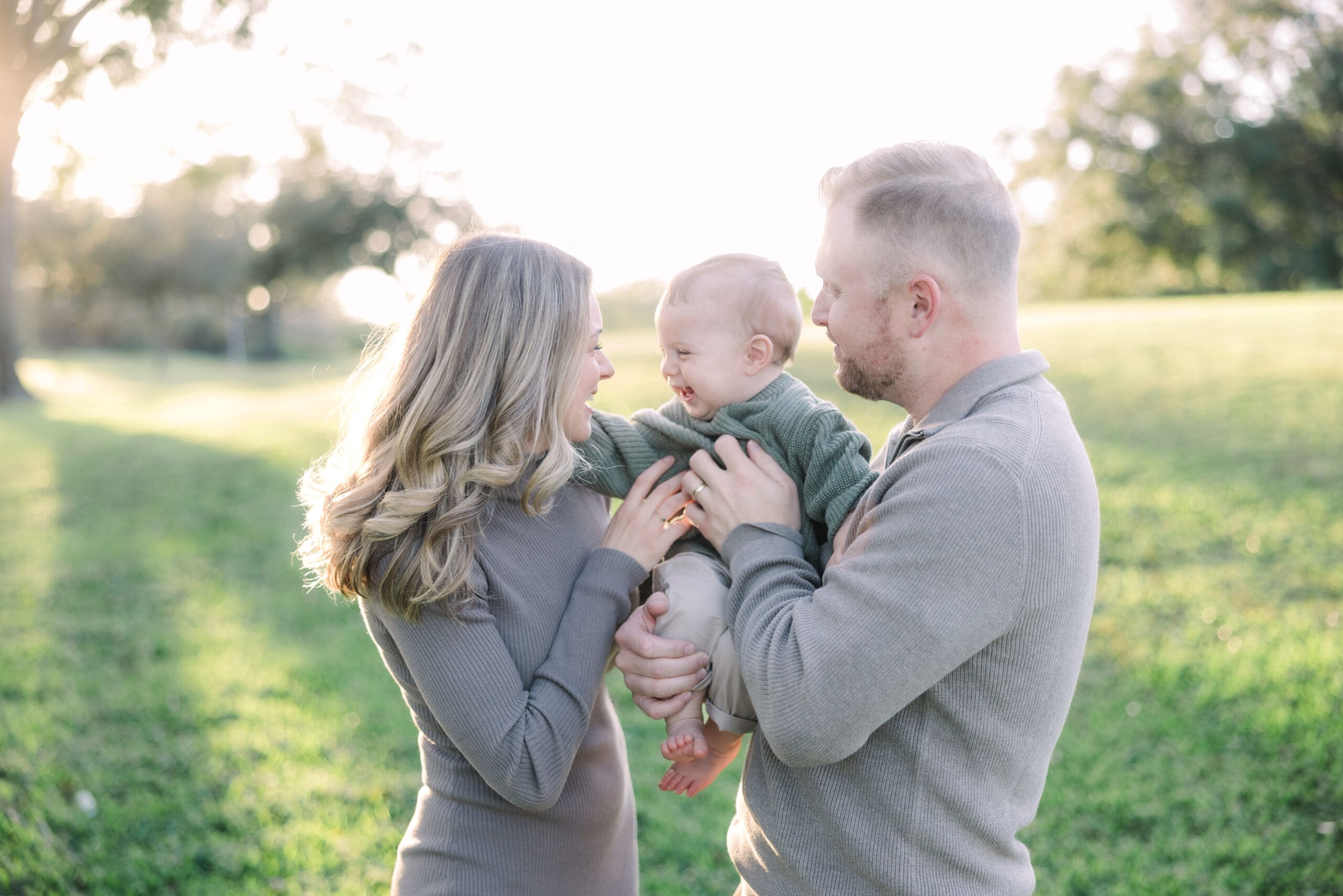 Mom and dad holding baby in a field during a Family photoshoot in Tampa