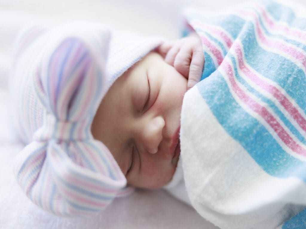 Newborn baby girl in hospital hat and swaddle during a Newborn and Fresh 48 photography session