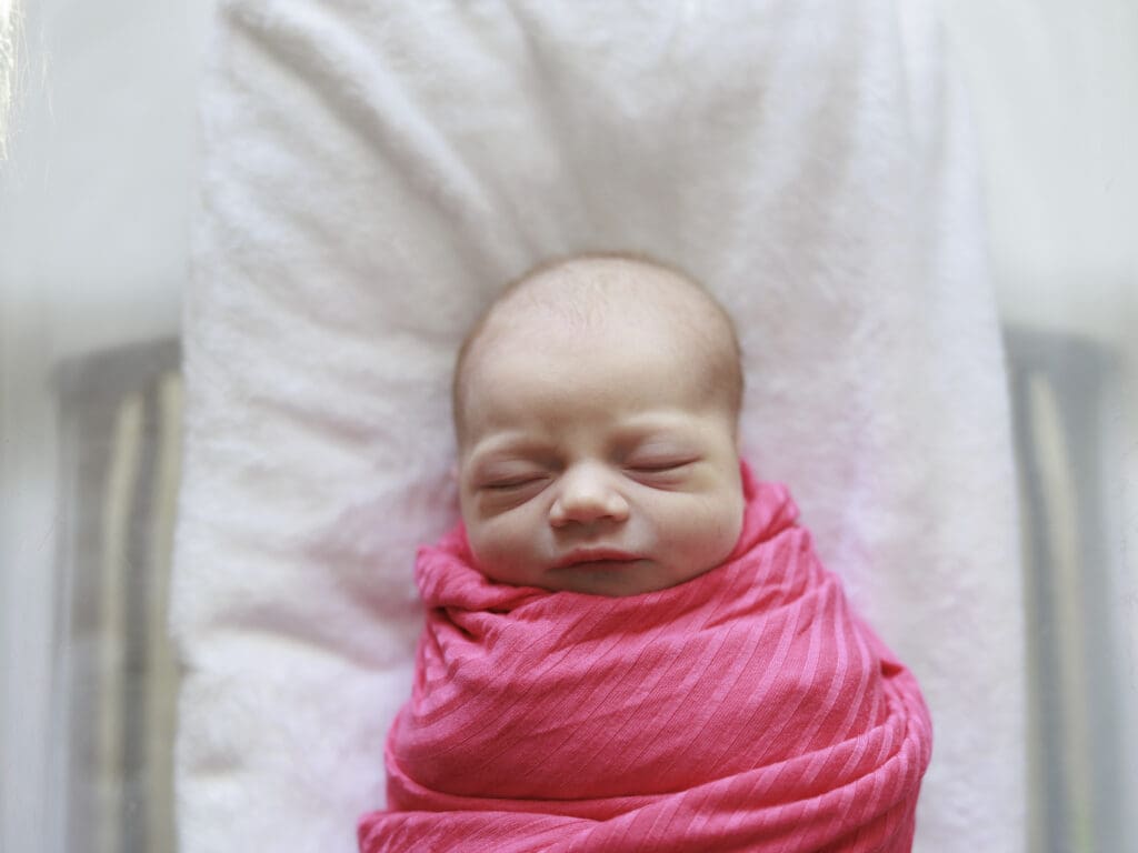 Newborn baby girl in a hot pink swaddle during Tampa Newborn Fresh 48 photography session.
