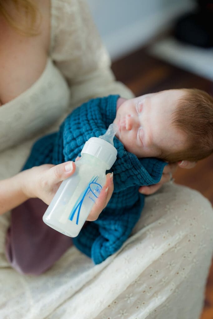 Sleepy newborn in elevated side-lying position as mother offers Dr. Brown’s bottle – bottle feeding newborn baby tips in Tampa