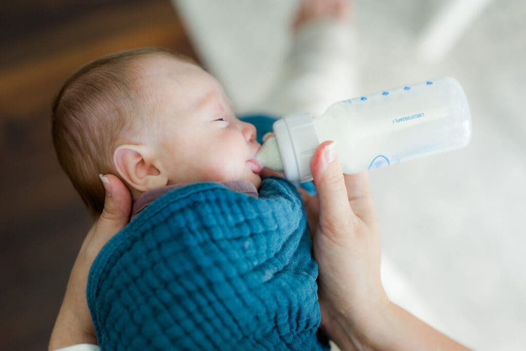 Close-up profile of newborn feeding from Dr. Brown’s bottle in elevated side-lying position – gentle bottle feeding newborn baby tips in Tampa