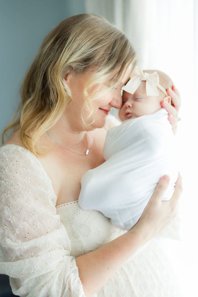 Tampa newborn photographer captures mother holding swaddled baby during calm portrait session