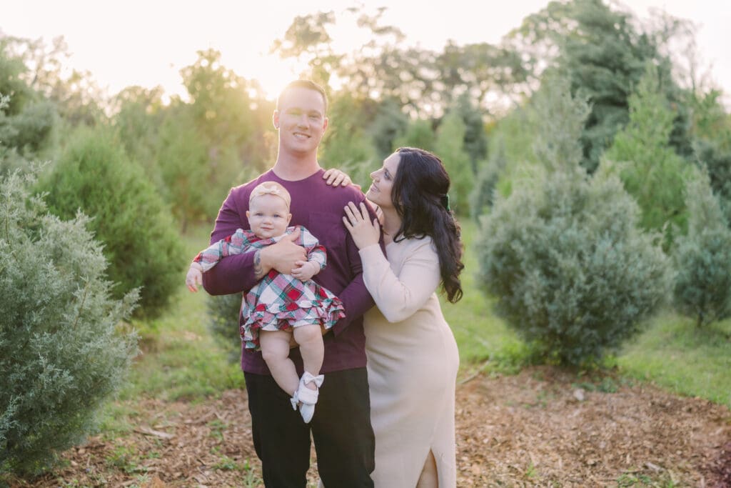 Couple with a baby for Tampa Family Photography Mini Session at Blue Acres Christmas Tree Farm.