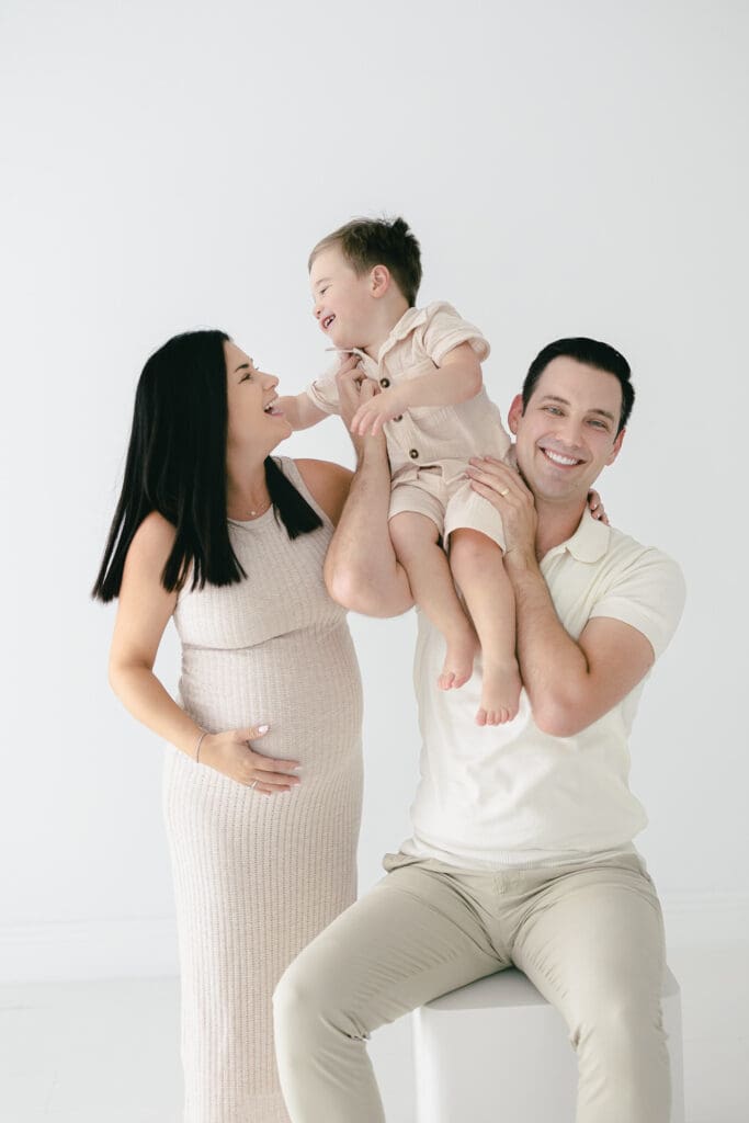 Lightly posed family photo in Tampa with mom, dad, and their toddler making a silly face during the session.